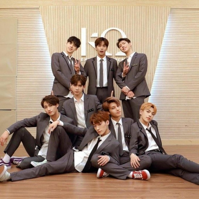 ATEEZ members holding GOLDEN HOUR: Part.3 album, symbolizing their 2025 Billboard success.