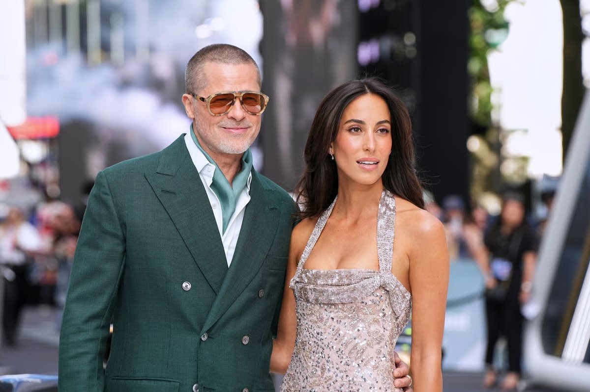 Brad Pitt in a green suit and Ines de Ramon in a beaded gown at the ‘F1’ premiere, symbolizing their 2025 red-carpet debut.