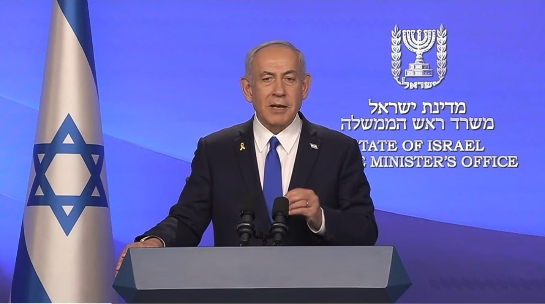 Benjamin Netanyahu speaking at a podium, with an Israeli flag backdrop, symbolizing the 2025 victory announcement.